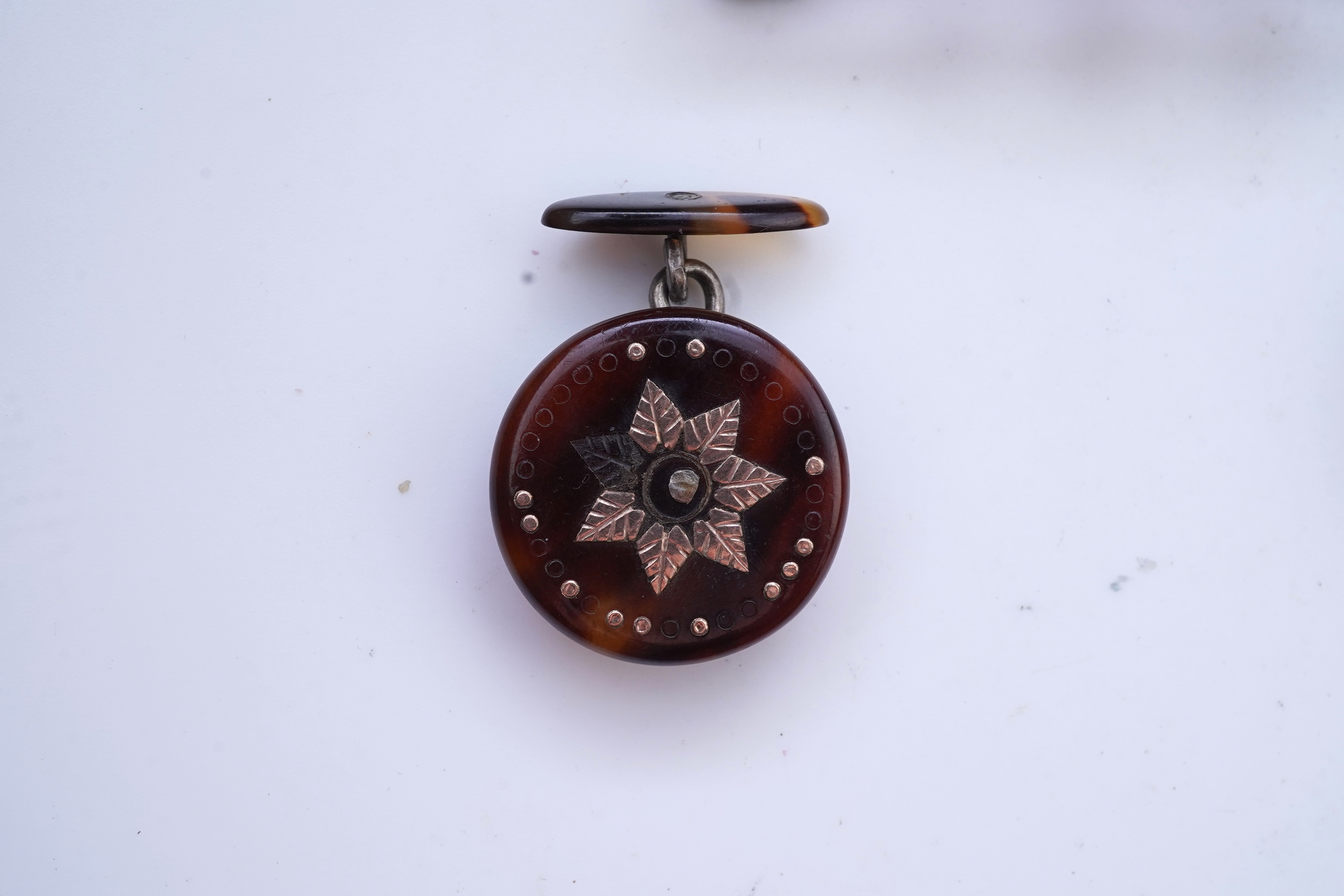 A Victorian yellow metal, amethyst and garnet cluster set brooch, 22mm, an early 20th century yellow metal and seed pearl set heart shaped locket, a yellow metal, garnet and zircon set three stone bar brooch and a tortoi